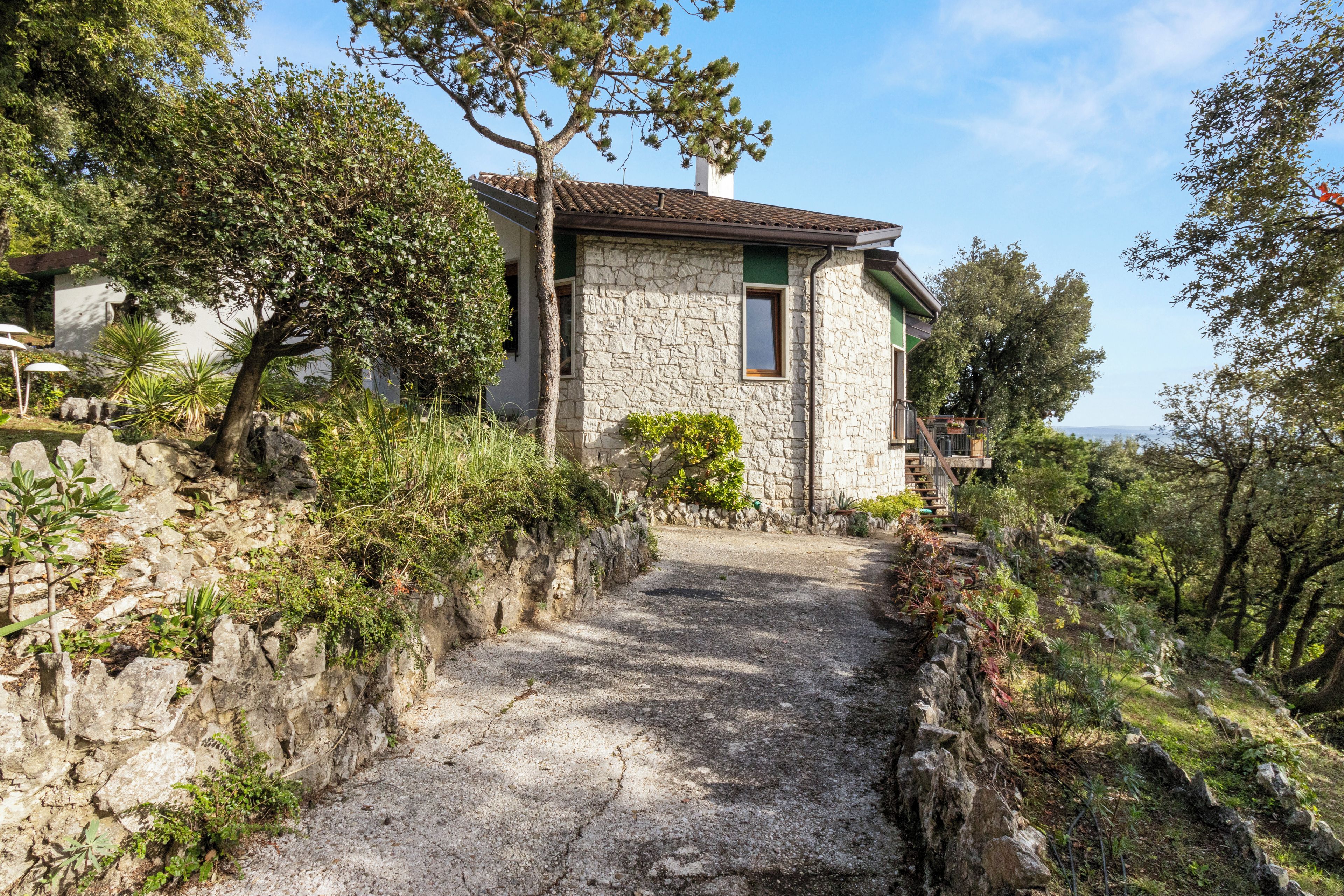 Une maison en pierre avec un chemin pavé menant à l’entrée.