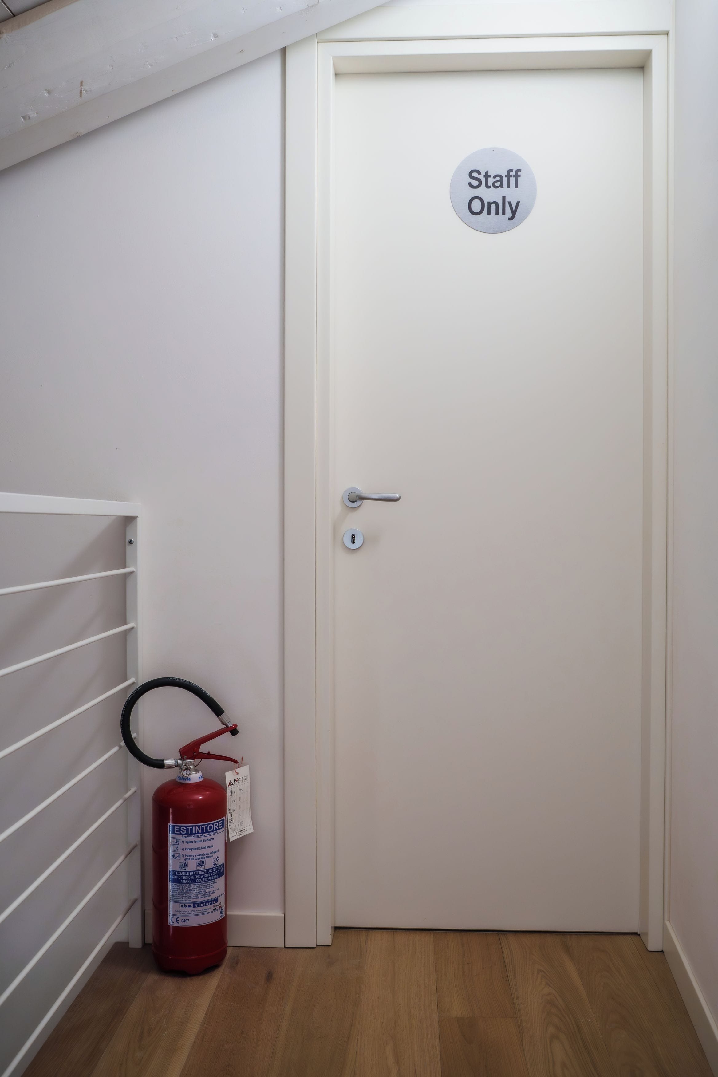 Une porte portant l’inscription « Réservé au personnel », un extincteur et un radiateur blanc.