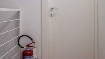 Une porte portant l’inscription « Réservé au personnel », un extincteur et un radiateur blanc.
