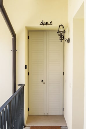 A double door with a doormat and a wall-mounted light fixture above it. - Urban Wine Studio Apartment con Terrazzo (Gorizia)