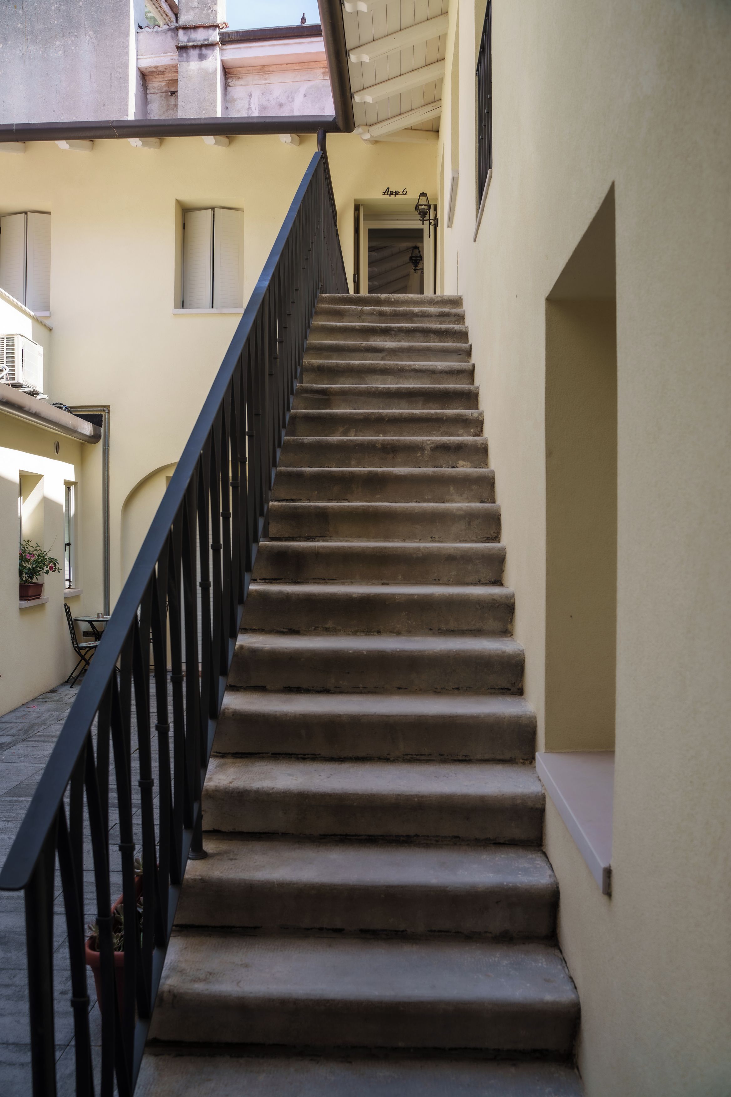 Eine Treppe mit schwarzer Gel änder, das zu einer oberen Etage führt.