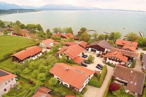 A residential area with houses, a lake, and mountains in the background. - Holiday apartment with 2 bedrooms (Chieming)
