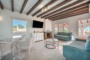 A spacious living area with a dining set, a sofa, and a fireplace.