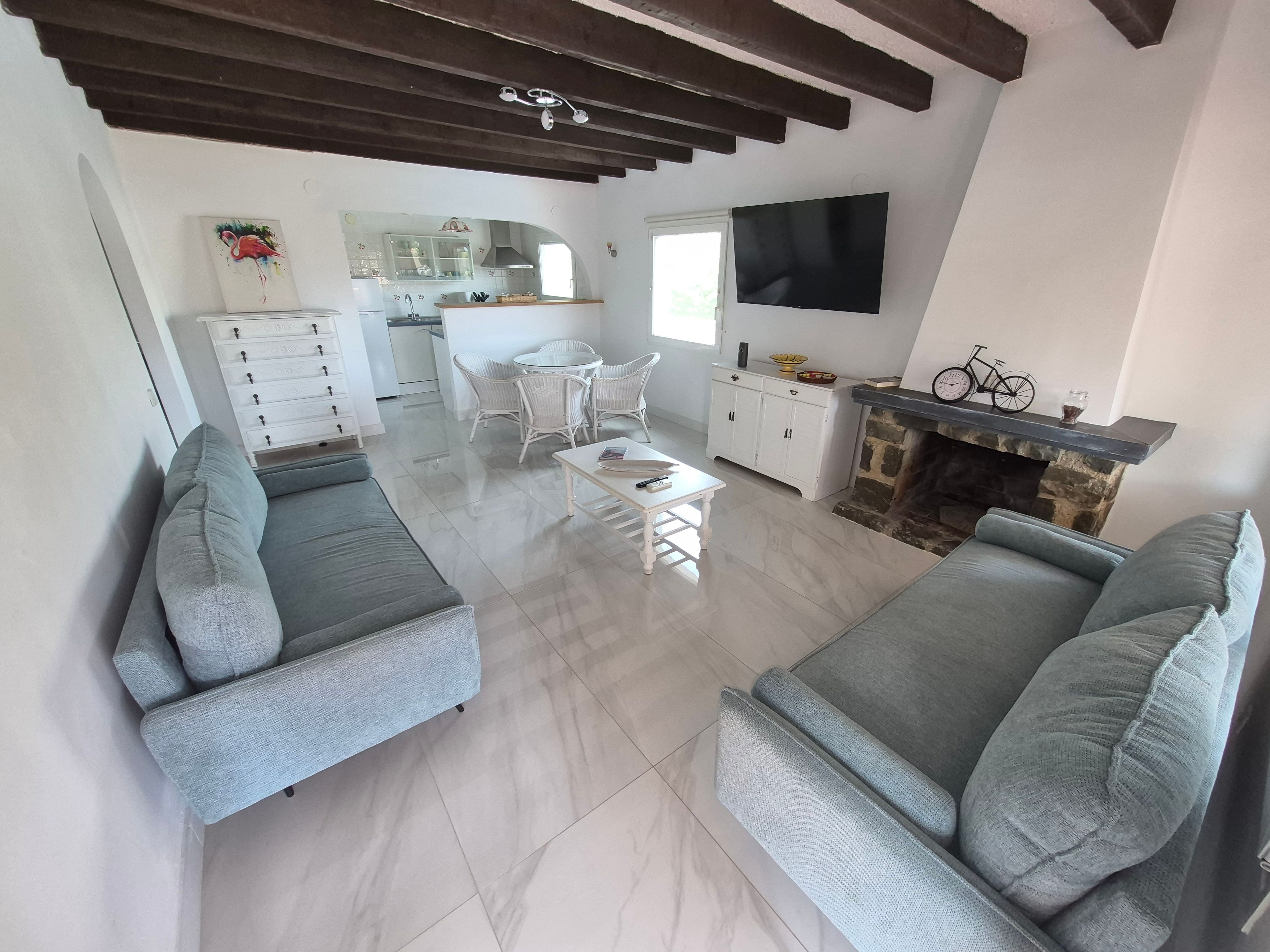 Ein modernes Wohnzimmer mit grauen Sofas, einem weißen Couchtisch und einem Kamin.