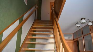 A wooden staircase with a handrail leading to a landing.