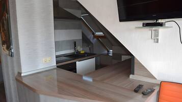 A compact kitchen with a built-in stove, a sink, and a small countertop.