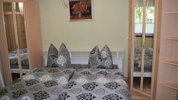Een slaapkamer met een bed, twee nachtkastjes, een schilderij en een raam.
