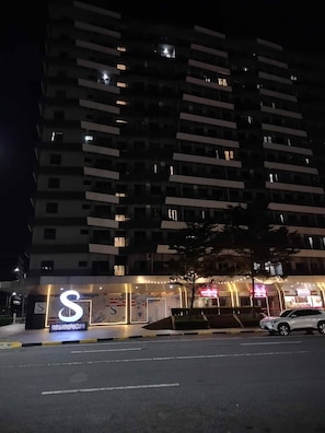 A multi-story building with illuminated windows and a sign for 'S Residences' at the ground level. - Modern, Comfortable Apartment in Central Pasay, Philippines (Pasay)