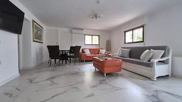 Un salón amplio con una mesa de comedor, sillas, un sofá y una mesa de centro.