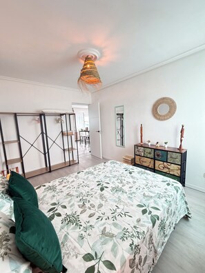 A bedroom with a bed, a dresser, a mirror, and a hanging light fixture. - Itos Flats, Cudillero (La Atalaya)