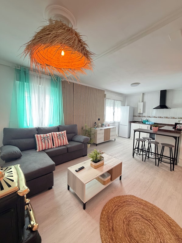 Una sala de estar moderna con un sofá, una mesa de centro y una lámpara colgante.