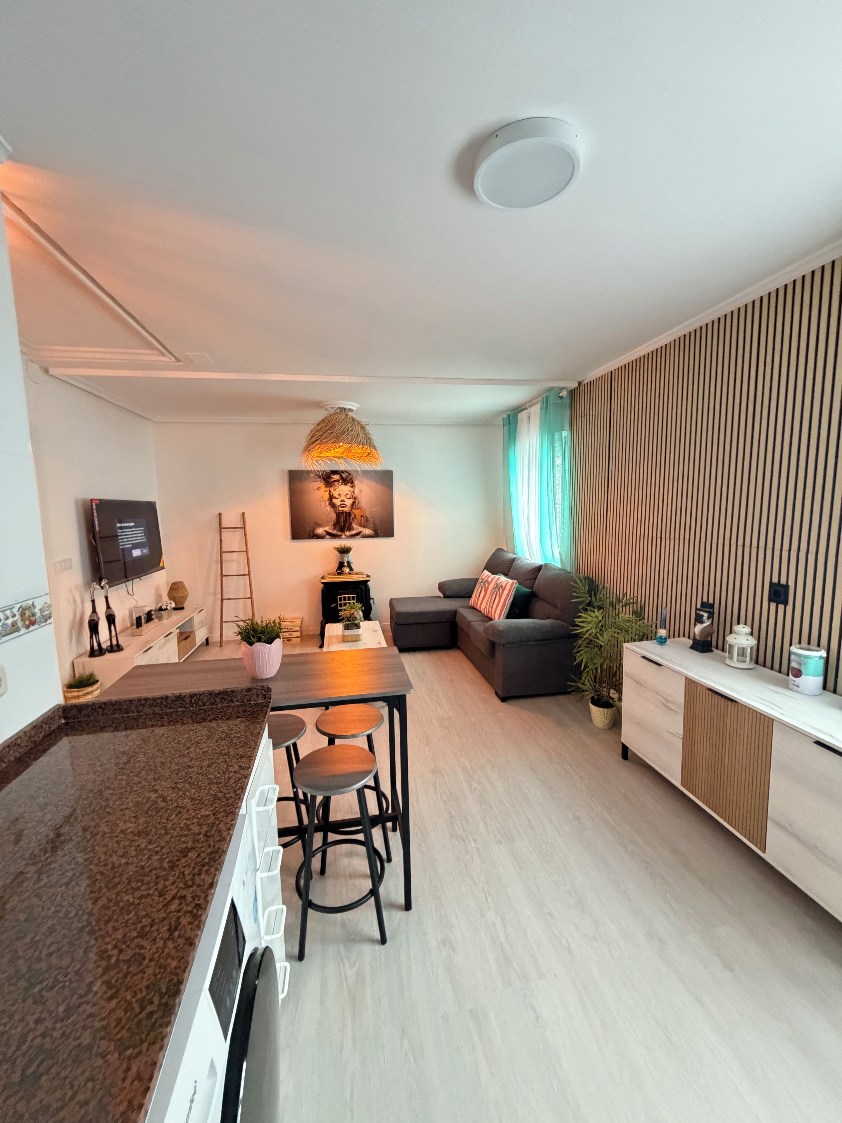A modern living space with a kitchen, dining area, and seating area.
