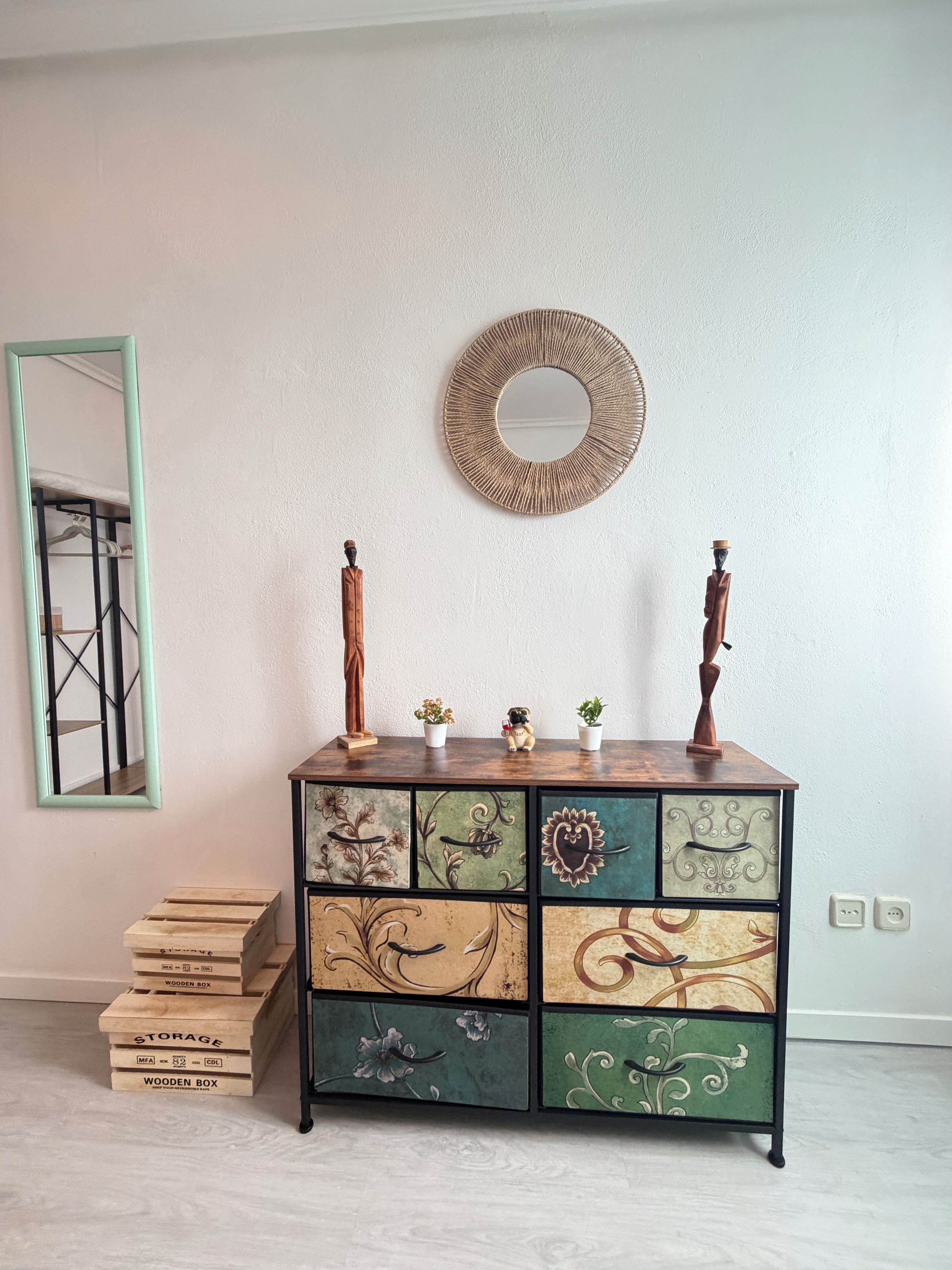 A wooden cabinet with decorative panels, a mirror, and two candle holders.