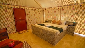 Una camera da letto con un letto, un comodino, un armadio rosso e una parete decorata.