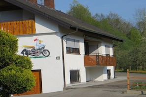 A two-story building with a mural of a motorcycle and a rooster, a balcony, and a gated entrance. - Holiday apartment with 1 bedroom (Stockach)