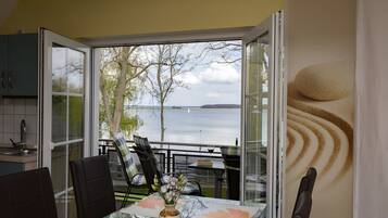 Un espace repas comprenant une table, des chaises et une vue sur l’eau.