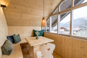 A wooden interior with a bench, table, and a hanging light fixture. - Holiday apartment with 1 bedroom (Oberstdorf)