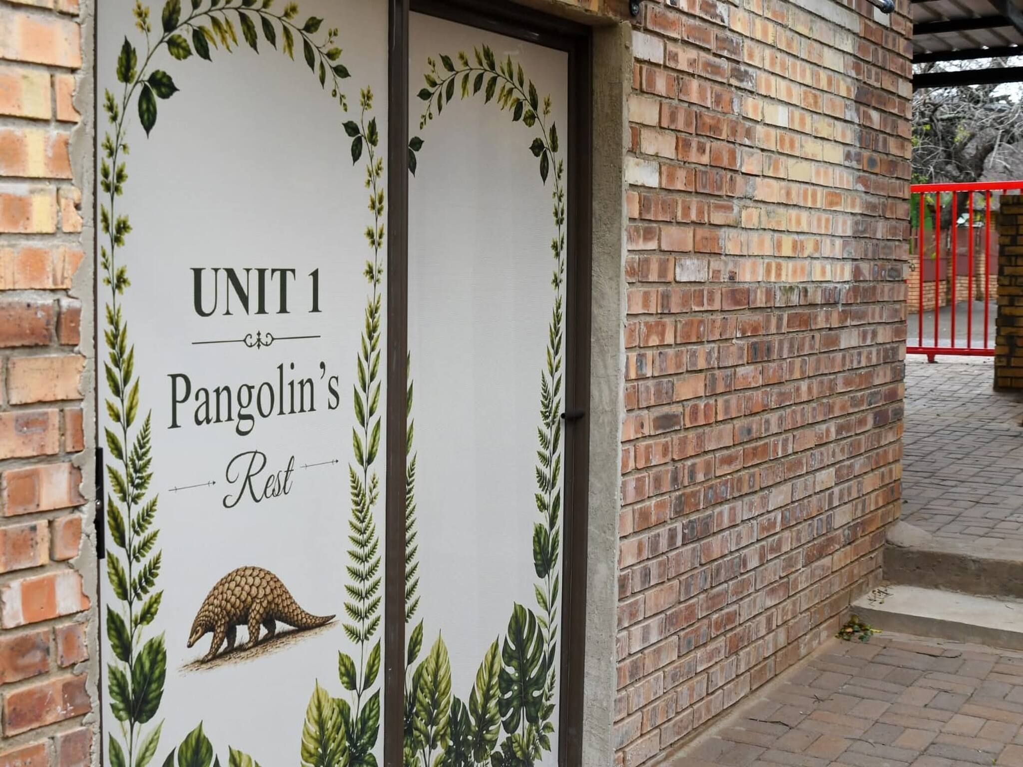 Un edificio in mattoni con un cartello che recita 'UNIT 1 Pangolin's Rest'.