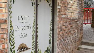 Un edificio in mattoni con un cartello che recita 'UNIT 1 Pangolin's Rest'.