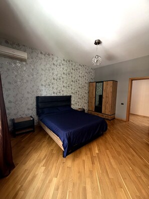 Une chambre à coucher comprenant un lit, une armoire et un appareil de climatisation.