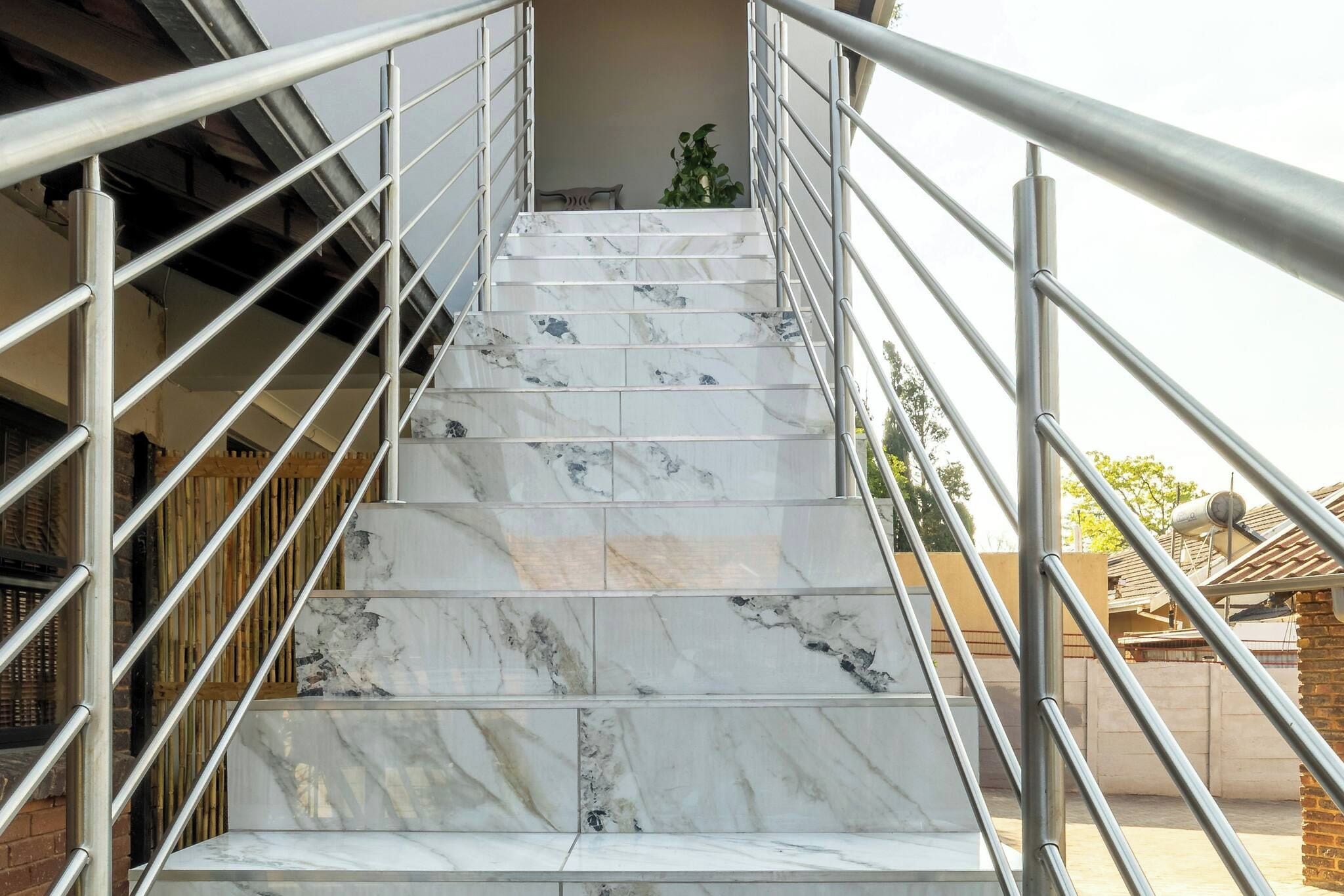 Una escalera con escalones de mármol y barandillas de metal.