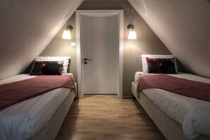 A room with two beds, a door, and two wall-mounted lamps. - Westerwald holiday villa (Schutzbach.)