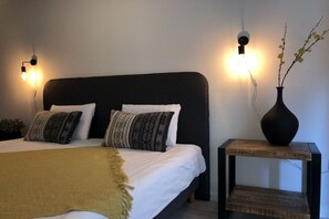 A bedroom with a bed, two bedside lamps, a bedside table with a vase, and a bedside plant. - Westerwald holiday villa (Schutzbach.)