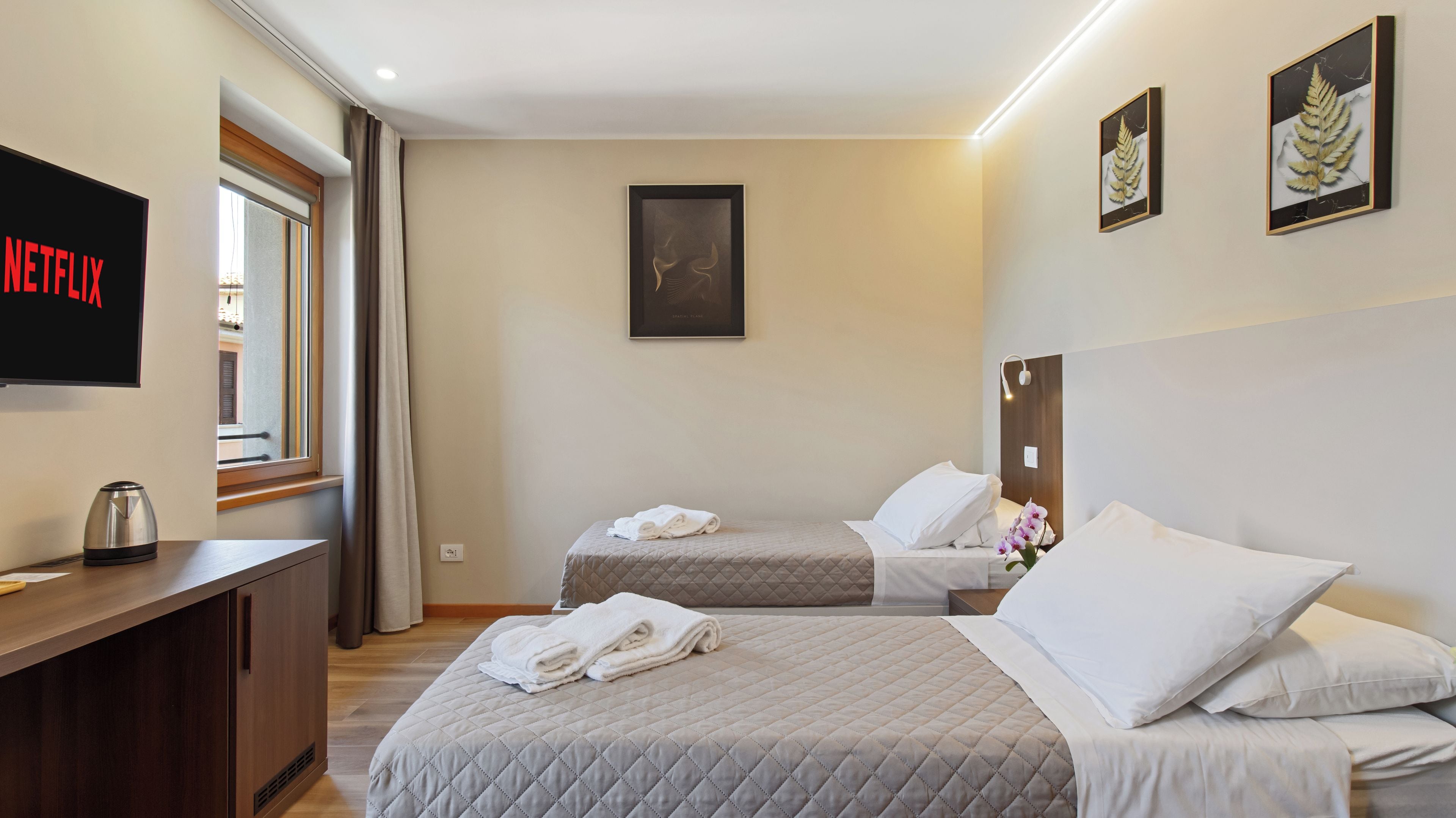 Une chambre d’hôtel avec un lit, un bureau, une télévision et une fenêtre.
