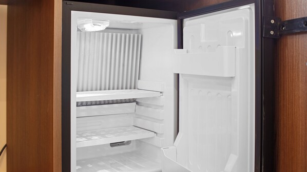 An open refrigerator with multiple shelves and a freezer compartment.