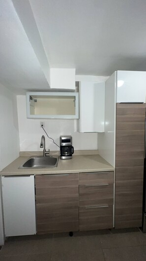 A compact kitchen with a sink, a coffee maker, and a refrigerator. - 2 Bedroom Apartment Ahuntsic (Montreal)