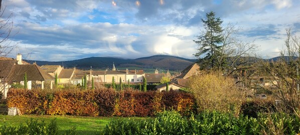 A rural village with traditional buildings, a church, and a mountain backdrop.