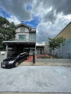 Ein zweistöckiges Wohnhaus mit einer Garage und einem schwarzen Auto davor.