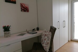 A room with a desk, a chair, a wardrobe, and a window. - Holiday home Holdschick (Altusried im Allgäu)