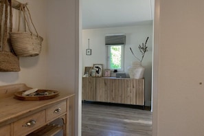 A reception area with a wooden desk, a basket, and a vase with dried plants.