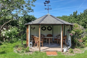A gazebo with a weather vane, surrounded by greenery and a small table with chairs. - Holiday apartment with 2 bedrooms (Bernkastel-kues OT Andel)