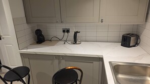 A kitchen with a countertop, a coffee maker, a toaster, and a sink. - Stylish Stay in Brighton London Road Gem (Brighton and Hove)