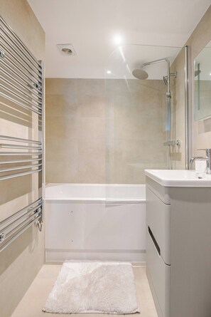 A modern bathroom with a bathtub, a shower, and a toilet. - Stylish Stay in Brighton London Road Gem (Brighton and Hove)