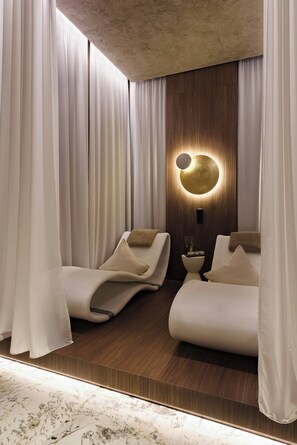 A modern bedroom with two beds, a wooden wall panel, and a circular light fixture. - Luxurious Accessible Apartment with Private Spa in Widen (Widen)