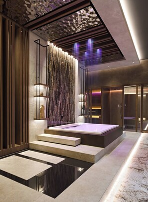 Un interior moderno con una bañera grande, paneles de madera y un techo decorativo.