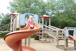 A playground with a spiral slide and climbing structures. - Water Villa Lisdodde (Workum)