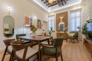 A spacious living area with a dining table, comfortable seating, and a large mirror. - San Francesco Boutique House by Wonderful Italy (Turin)