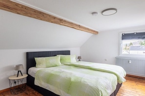 A bedroom with a bed, a window, and a radiator. - Holiday apartment with 1 bedroom (Simmerath)