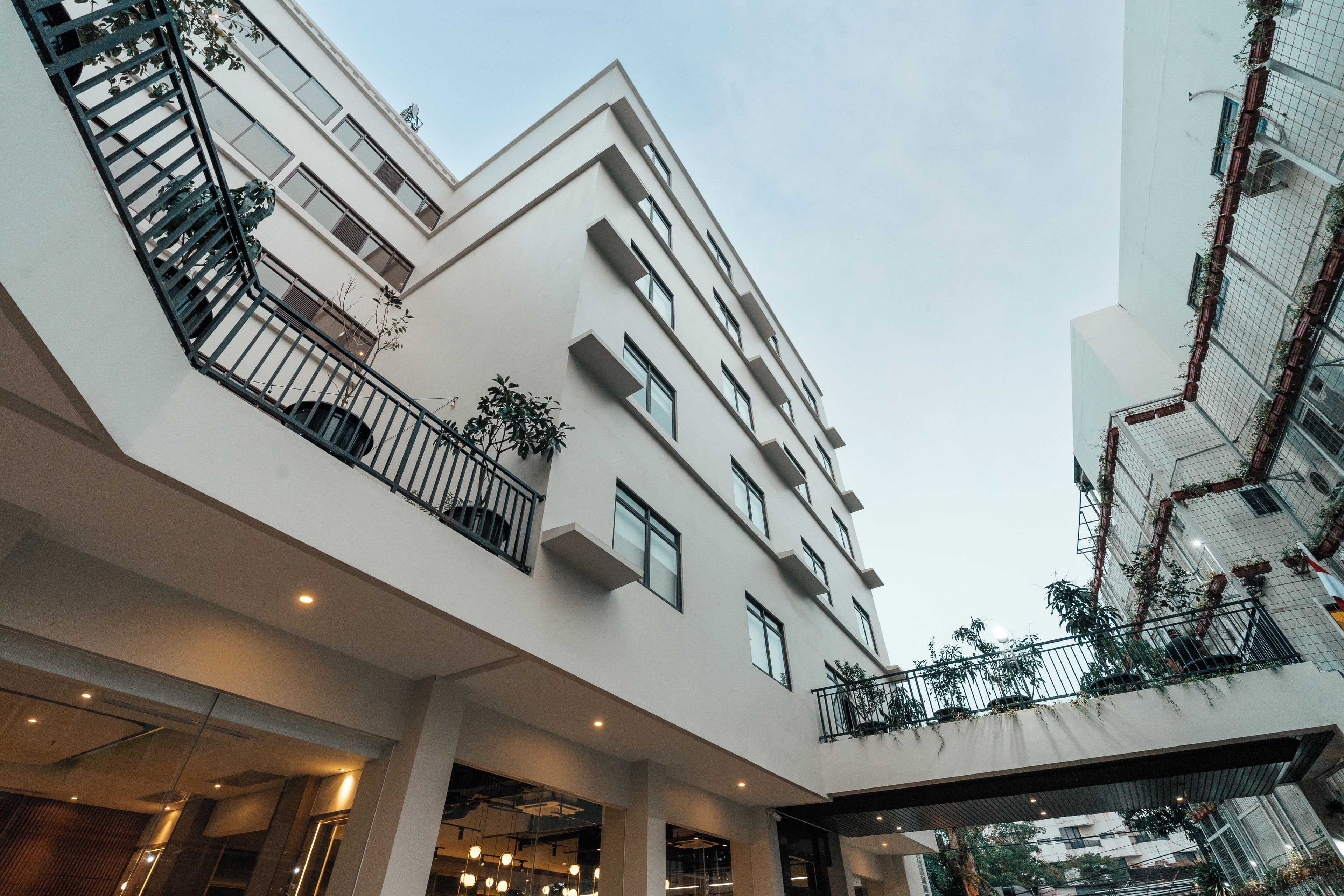 Un edificio de varios pisos con balcones, grandes ventanales y un espacio abierto central.
