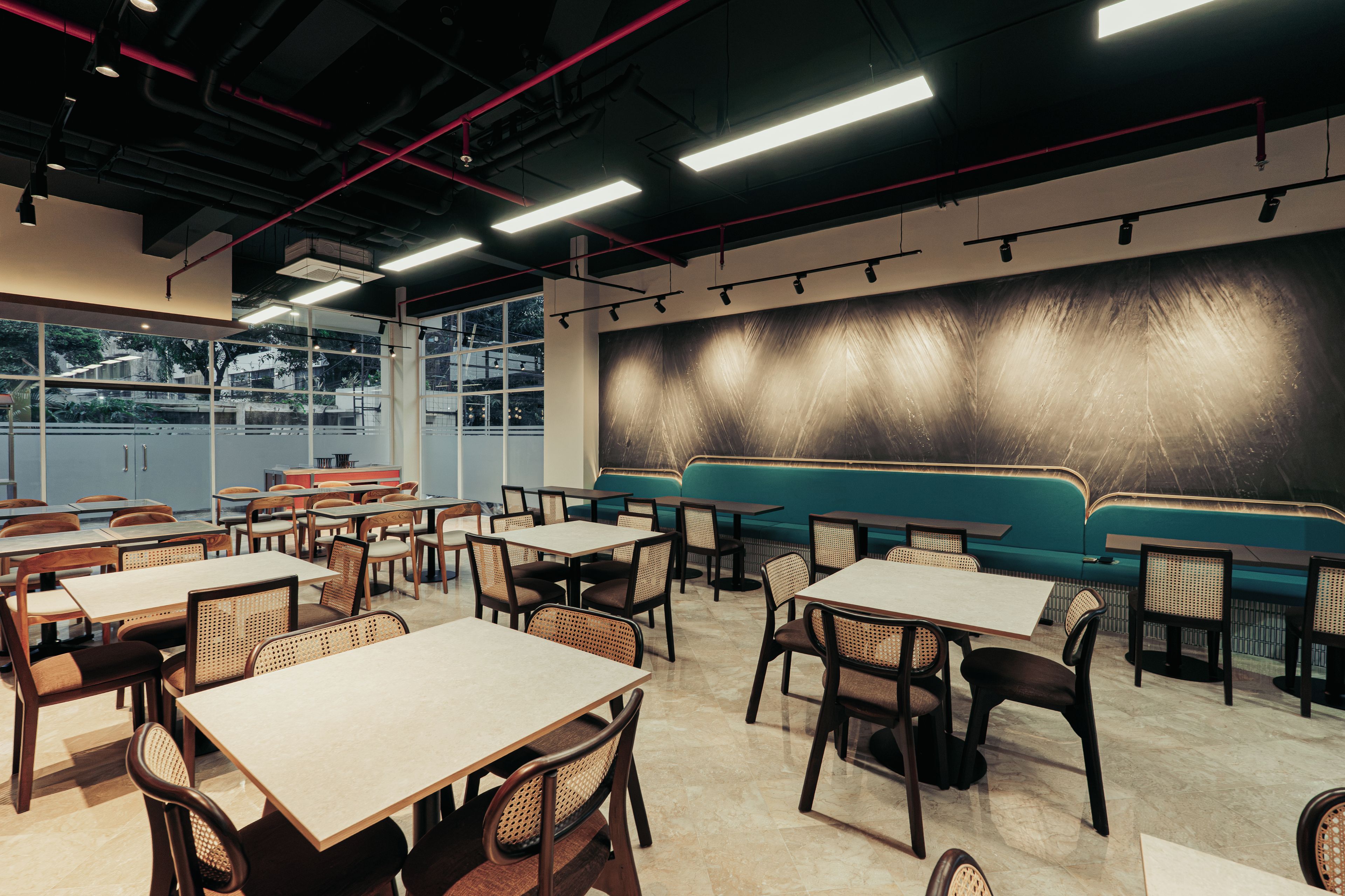 A restaurant interior with tables, chairs, and a seating area.