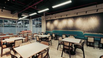 A restaurant interior with tables, chairs, and a seating area.