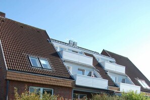 A residential building with a sloped roof, multiple windows, and a brick facade. - Holiday apartment with 1 bedroom (Wyk auf Föhr)