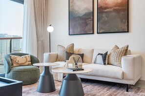 A modern living room with a sofa, armchairs, a coffee table, and a floor lamp. - Contemporary 1BR with a Spacious Balcony Overlooking the Creek (Dubai)