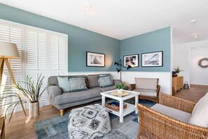 A living room with a sofa, chairs, a coffee table, and wall art. - Holiday apartment with 2 bedrooms (Kappeln, Ostseeresort Olpenitz)