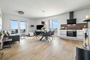 A modern apartment with a dining area, kitchen, and living space. - Apartment in Olpenitz with swimming pool (Olpenitz)