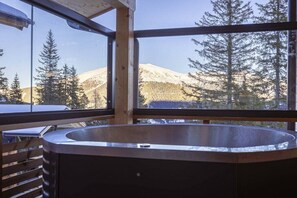 A hot tub with a view of snow-covered mountains and trees. - Superior Chalet # 6 with Sauna & Hot Tub (Turrach)